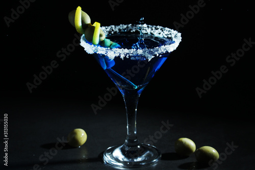 A glass with blue martini cocktail	