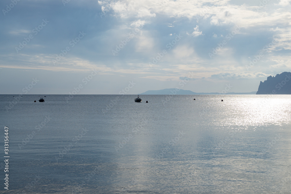 Obraz premium Blue sky with white clouds over the sea and mountains. Two Anchor Bay in Ordzhonikidze, Crimea. Beautiful clouds and natural sky background