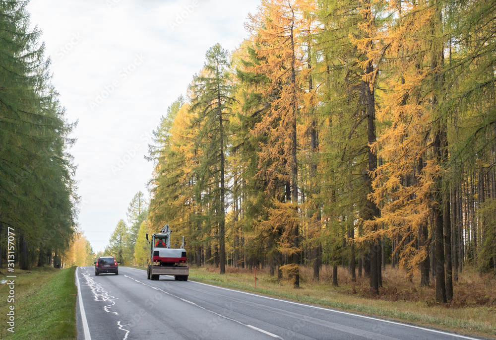 Obraz premium Passenger car using opposing lane while passing a digger