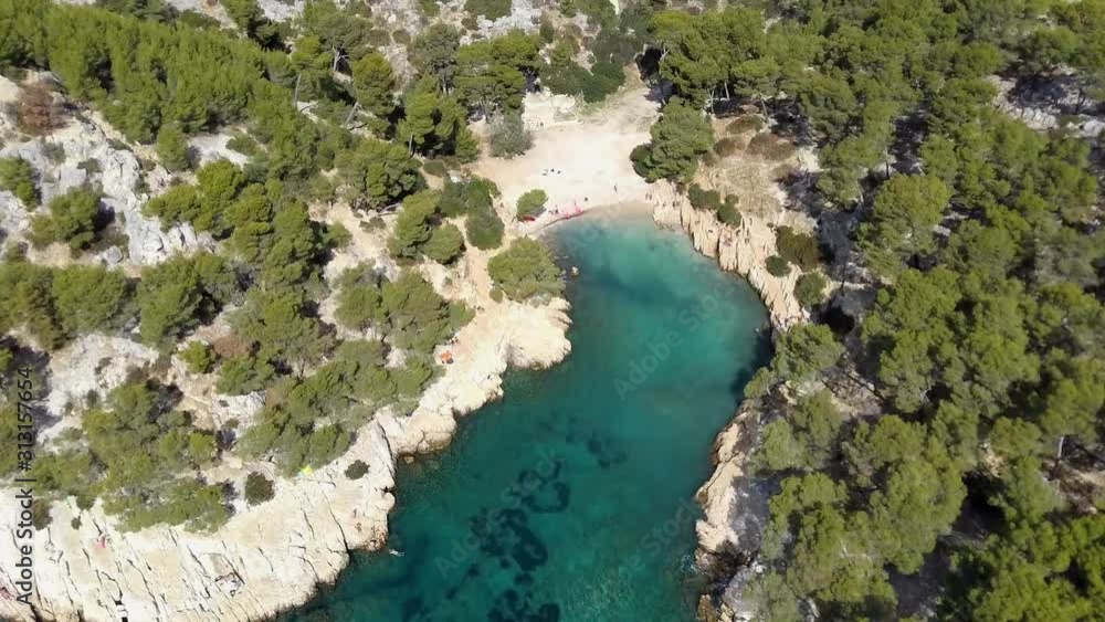 Aerial drone shot flying over the calanque d'en vau in south of france. Beautiful creek with trees and clear water, sunny day. Aerial drone shot flying over the calanque d'en vau in south of france. Beautiful creek with trees and clear water, sunny day.