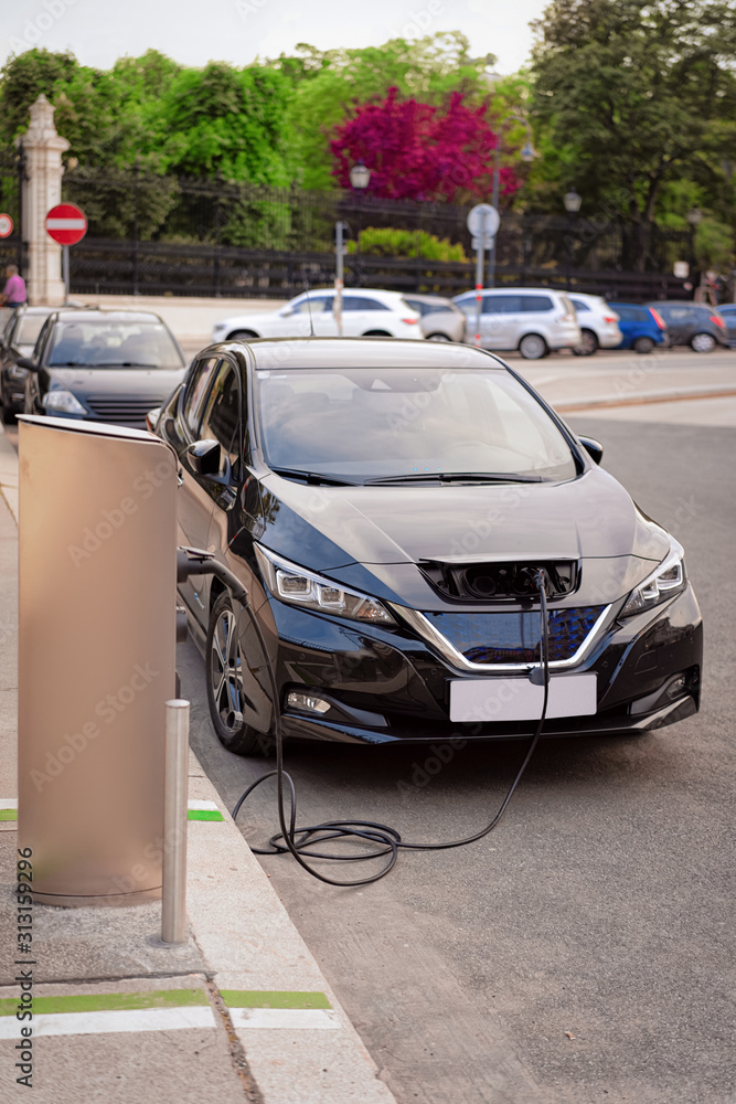 Electric Car Charging station at Vienna in Austria. Battery hybrid vehicle eco charger. Future energy power. Green technology. Transport and plug. Fuel recharge. Clean ecology concept. Modern supply - obrazy, fototapety, plakaty 