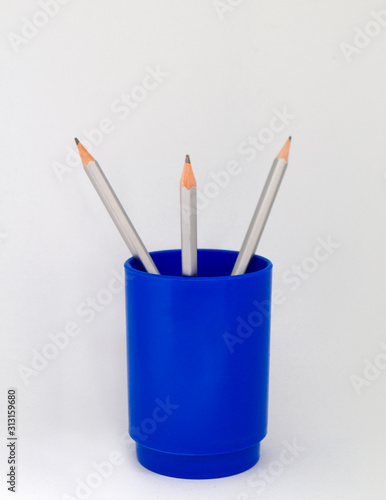 Blue plastic pencil holder with pencils. School and student material