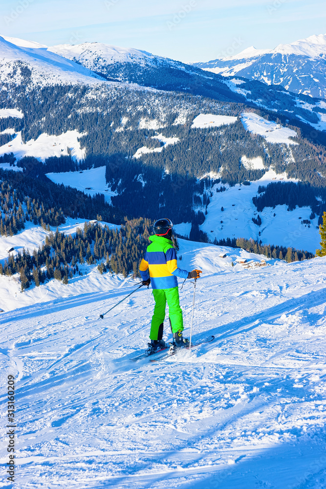 Child Skier skiing in ski resort Penken Park in Tyrol in Mayrhofen in Zillertal valley in Austria in winter Alps. Kid ski Alpine mountains with white snow and blue sky. Austrian snowy slopes.