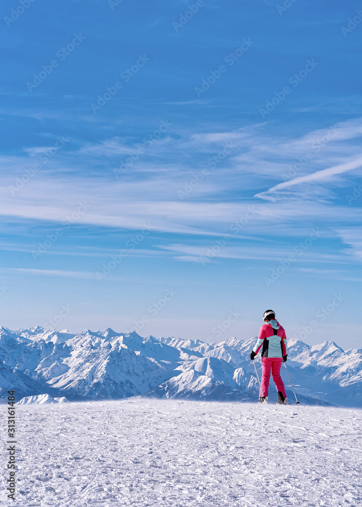 Woman Skier skiing in Hintertux Glacier in Tyrol in Mayrhofen, Austria, winter Alps. Lady girl Ski at Hintertuxer Gletscher in Alpine mountains with white snow and blue sky. Sun shining.