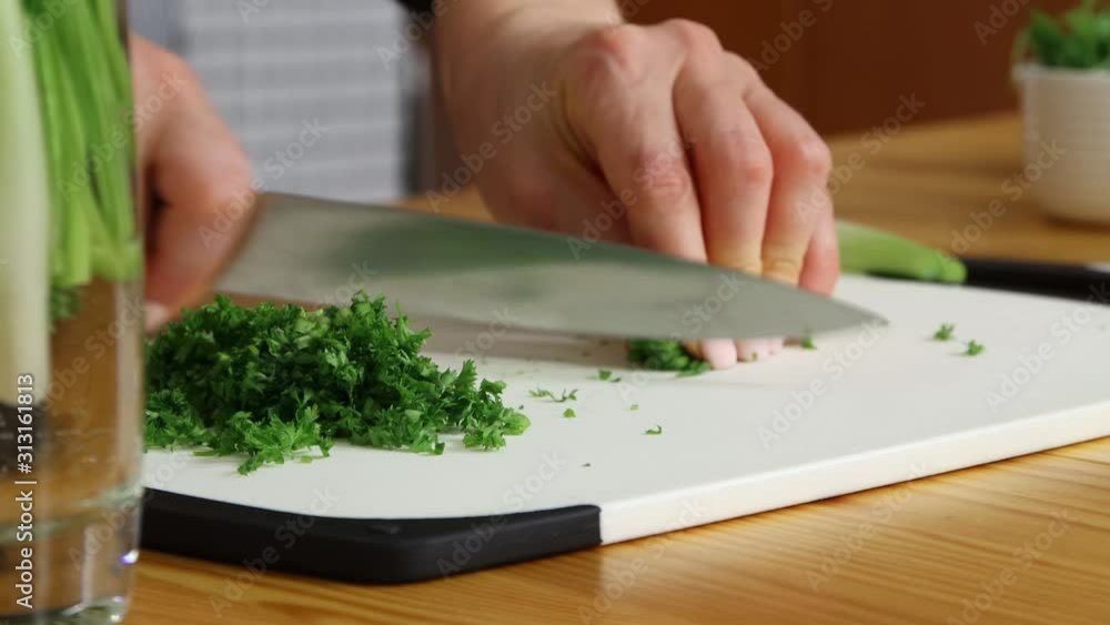 Chopping green onion on cutting board Chopping green onion on cutting board