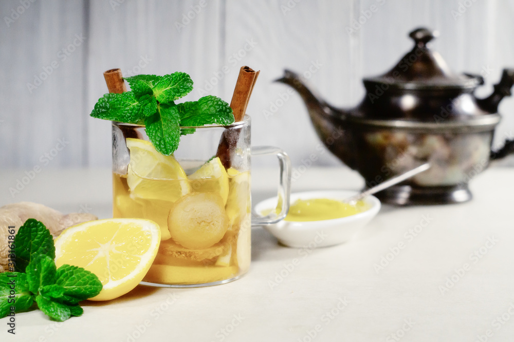 Hot drink with lemon, ginger, honey and cinnamon in a glass cup Hot drink with lemon, ginger, honey and cinnamon in a glass cup