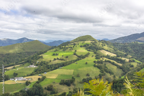 View from the mountain. The top viewpoint. Forests and colorful fields. The nature of France. Walking in Europe. Green tourism. Panorama of green hills. Mountains in the clouds.