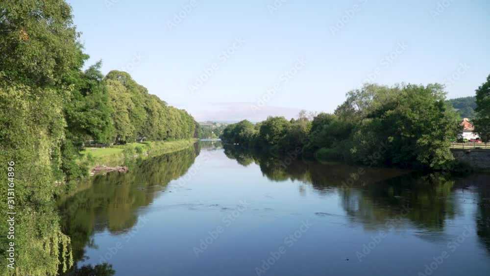Wide shot River Wye with trees reflected on calm waters Builth Wells, Wales Uk Wide shot River Wye with trees reflected on calm waters Builth Wells, Wales Uk
