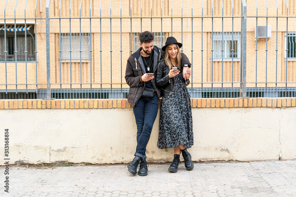 Young couple in the city using their mobile phones
