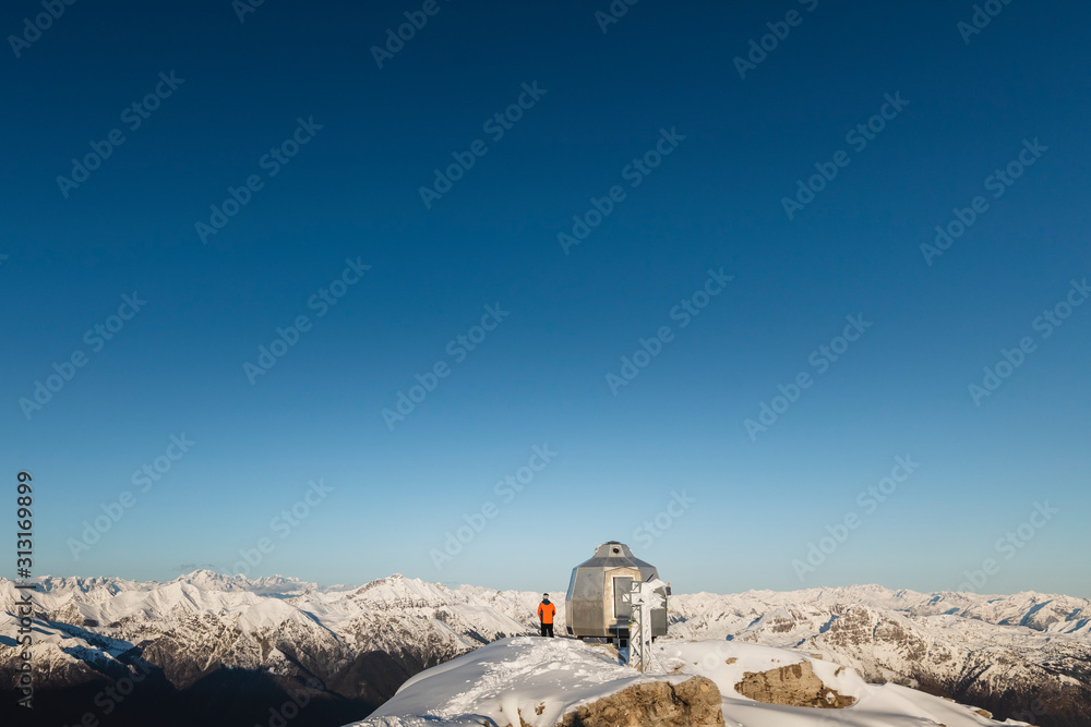 Mountaineer standing on top of a snowy mountain enjoying the view Mountaineer standing on top of a snowy mountain enjoying the view