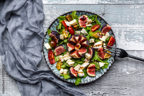 Autumnal salad with figs, arugula, mozzarella and tomatoes photo