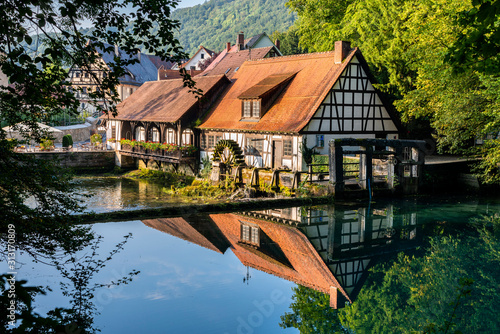 Countryside cottages reflecting in shiny river photo