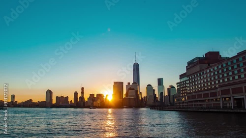 Time lapse in motion or hyper-lapse of sunrise over Hudson River overlooking New York city skyline, tall skyscraper buildings, Freedom Tower in Manhattan USA.