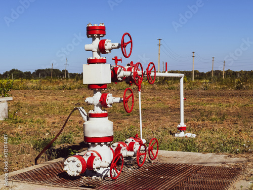 Well for oil and gas production. Oil well wellhead equipment. Oil production photo