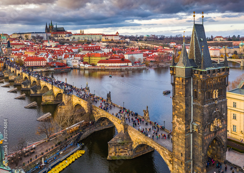 Prague, Czech Republic - Aerial drone view of the world famous Charles Bridge (Karluv most) above River Vltava with a colorful winter sunset and St.Vitus Cathedral at background