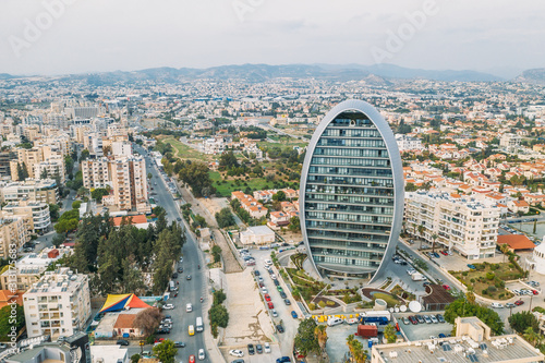 Modern business center with offices in shape of oval or egg in Limassol downtown near embankment  aerial view from drone.