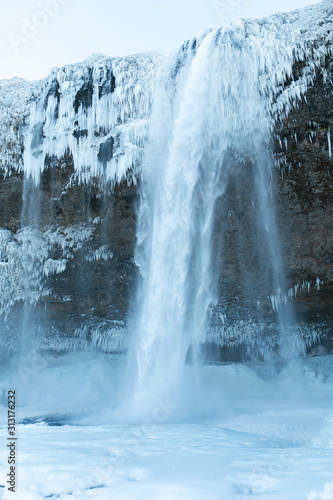 A huge waterfall frozen in icicles in winter. Winter Landscapes of Iceland