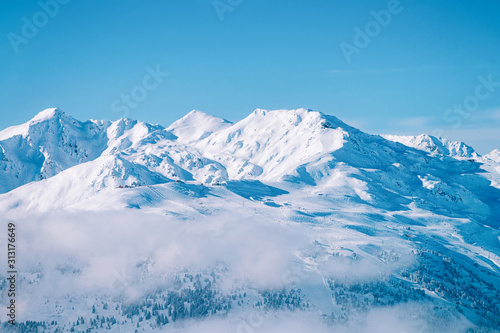 Landscape in Zillertal Arena ski resort in clouds in Tyrol at Mayrhofen in Austria in winter Alps. Alpine mountains with white snow and blue sky. Downhill peaks at Austrian snowy slopes. © Roman Babakin