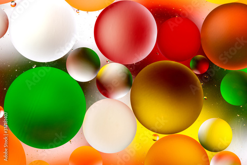 bright oily drops in water with colorful background, close-up 