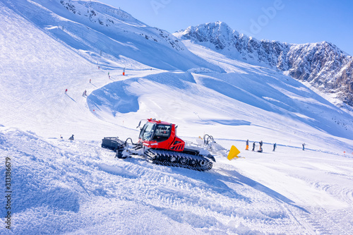 Men Skiers and snowboarders at Hintertux Glacier in Tyrol in Mayrhofen, winter Alps. People with Ski and snowboard at Hintertuxer Gletscher in Alpine mountains. Snowcat ratrack working on background