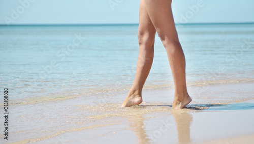 Female legs on the beach. Summer time concept.