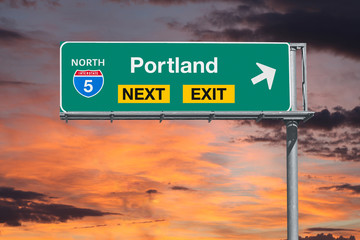 Portland Oregon next exit route 5 freeway sign with sunset sky.