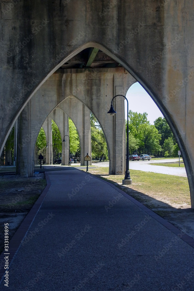 sidewalk beneath old concrete bridge