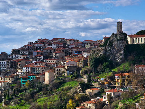 View to Arachova village, Greece with iconic tower clock, under cloudy sky.