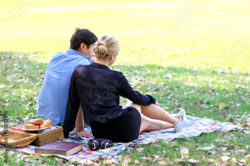 Sweet couple relaxing on picnic in park, young beautiful lover spending time together and having romantic moment in summer garden, love and romantic date concept