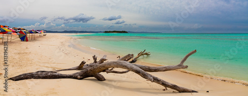 Colourful umbrellas on a tropical beack on Nosy Iranja in Madagascar