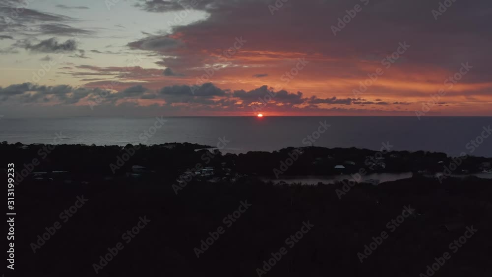 Static aerial as sun goes down behind water on horizon, island of Roatan Static aerial as sun goes down behind water on horizon, island of Roatan