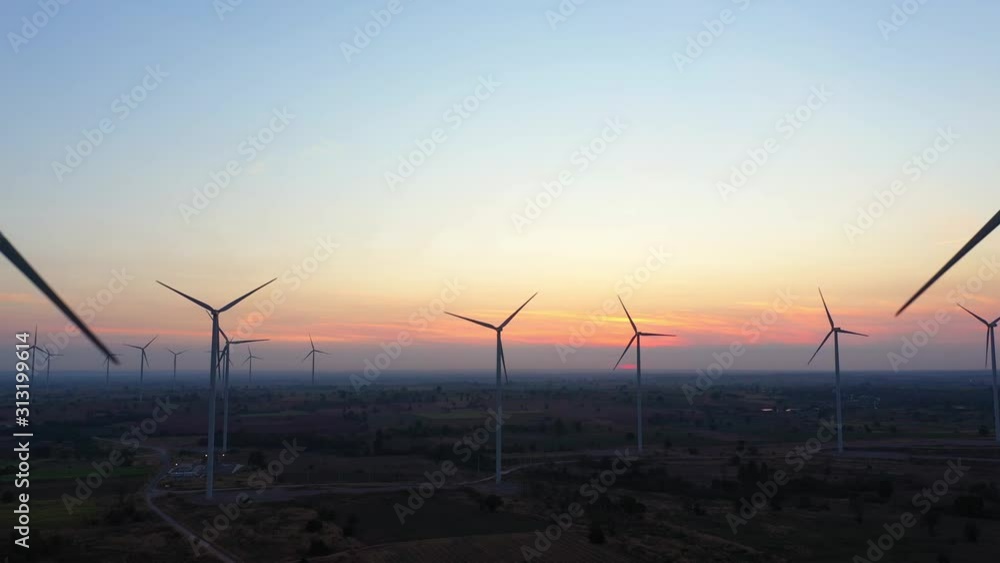 Aerial view of Wind turbines of save Energy save world in video 4k format. aerial shot on sunset. drone footage wind turbines at sunrise with beautiful clouds. Global warming concept and green energy. Aerial view of Wind turbines of save Energy save world in video 4k format. aerial shot on sunset. drone footage wind turbines at sunrise with beautiful clouds. Global warming concept and green energy.