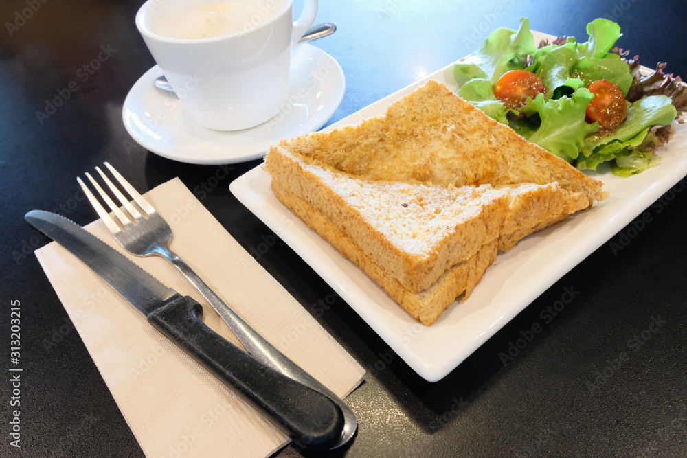 breakfast set serve on table, hot cappuccino coffee in white ceramic glass with tasty whole wheat bread sandwich ham cheese and salad vegetable. healthy food for start the day in the morning. breakfast set serve on table, hot cappuccino coffee in white ceramic glass with tasty whole wheat bread sandwich ham cheese and salad vegetable. healthy food for start the day in the morning.