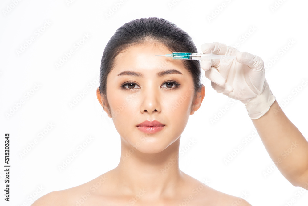 Asain young woman gets injection  in her lips. Woman in beauty salon. plastic surgery clinic.Beautiful woman gets  injection in her face.
