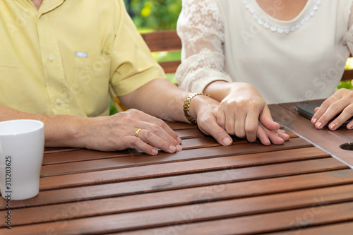 Senior Asian couple holding hand.