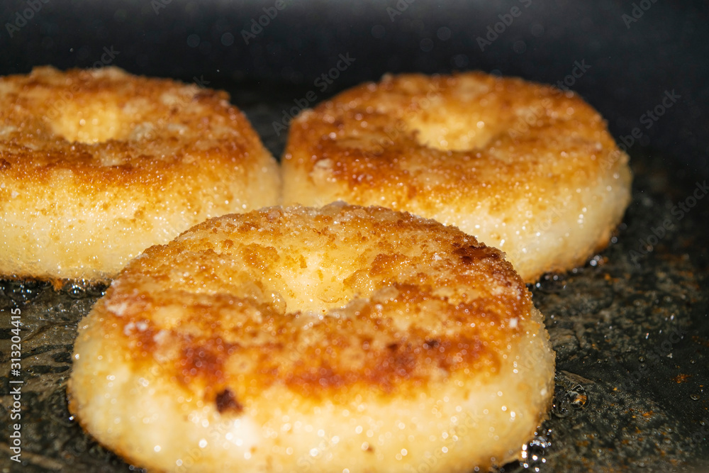 Three minced chicken cutlets are fried in a pan in vegetable oil. Close up.