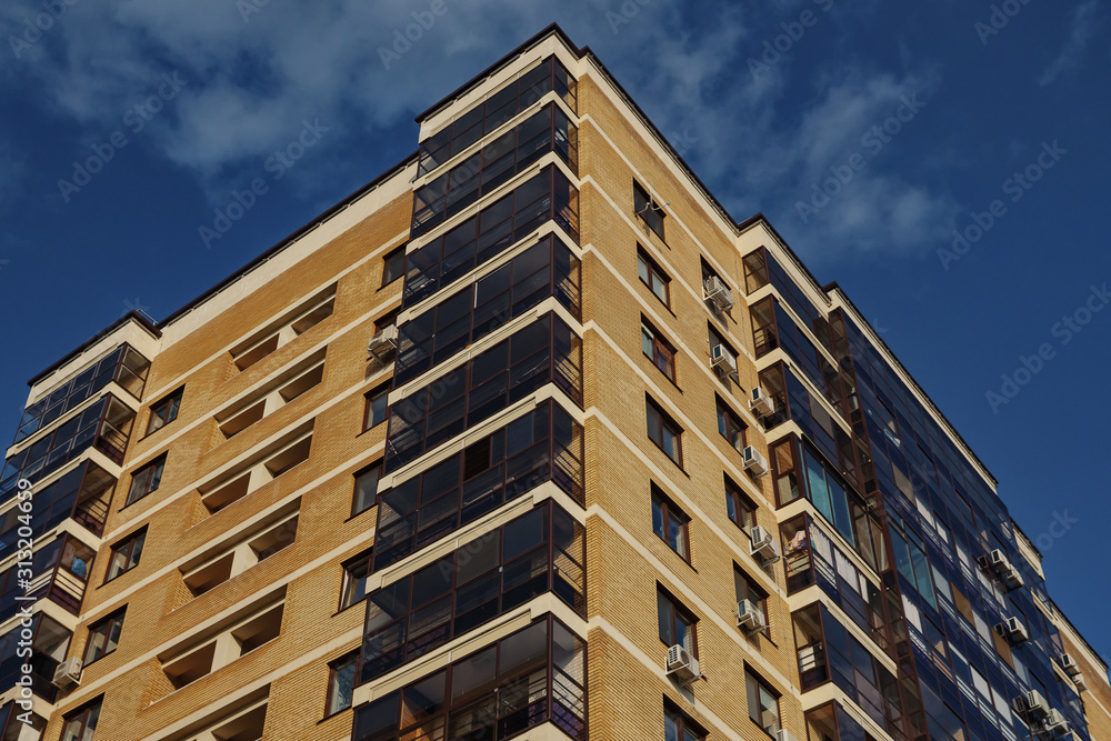 New multi-storey brick house against a clear sky. New multi-storey brick house against a clear sky.