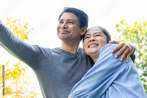 Senior Asian couple embrace together at the garden.