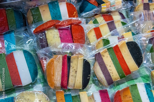 Slika na platnu Brightly coloured favored cheese wrapped for sale at a market.