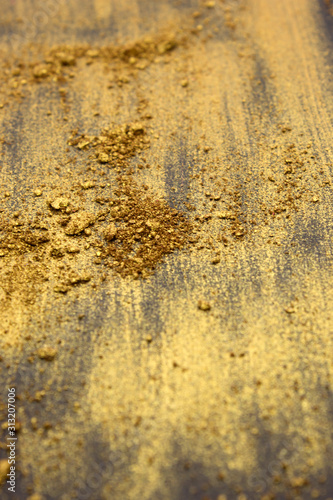 This is a photograph of a Gold powder Eyeshadow isolated on a Black background