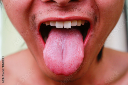 Close up image of young man showing tongue