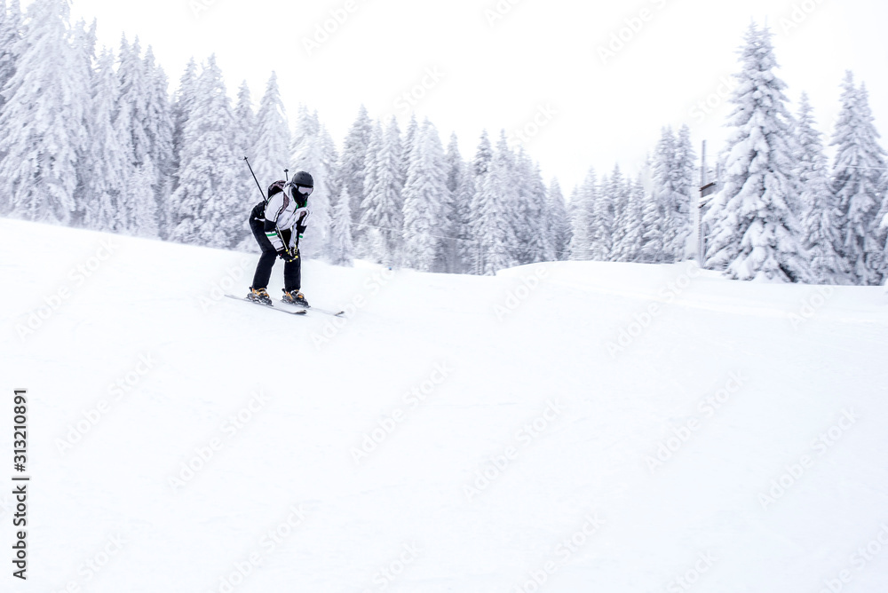 Skier skiing downhill in mountains during winter season