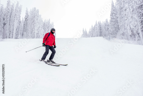 Skier skiing downhill in high mountains during winter season