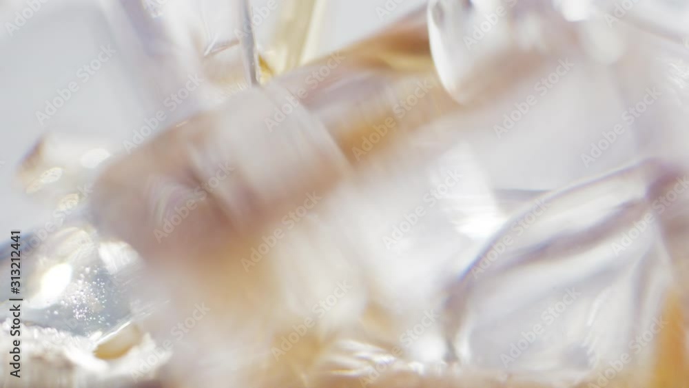 Macro shot of soda pop pouring over ice cubes in a rotating glass shot in 4K Macro shot of soda pop pouring over ice cubes in a rotating glass shot in 4K