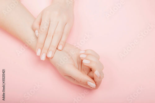 Stylish trendy manicure nail young woman hands on pink background, top view
