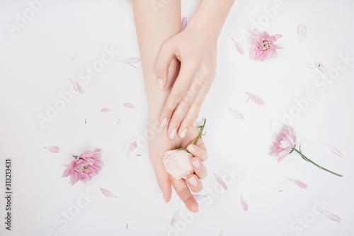 Concept beauty. Beautiful stylish trendy female pink manicure with flower on background  top view
