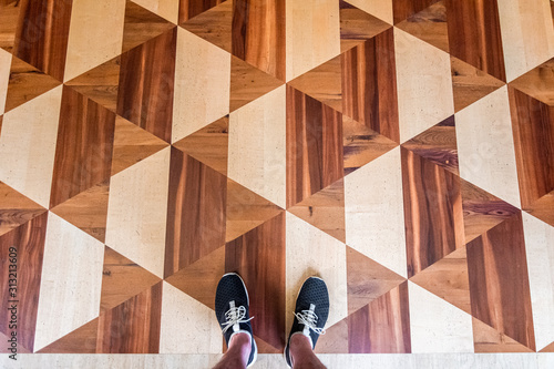 Black sneakers on parquetry flooring