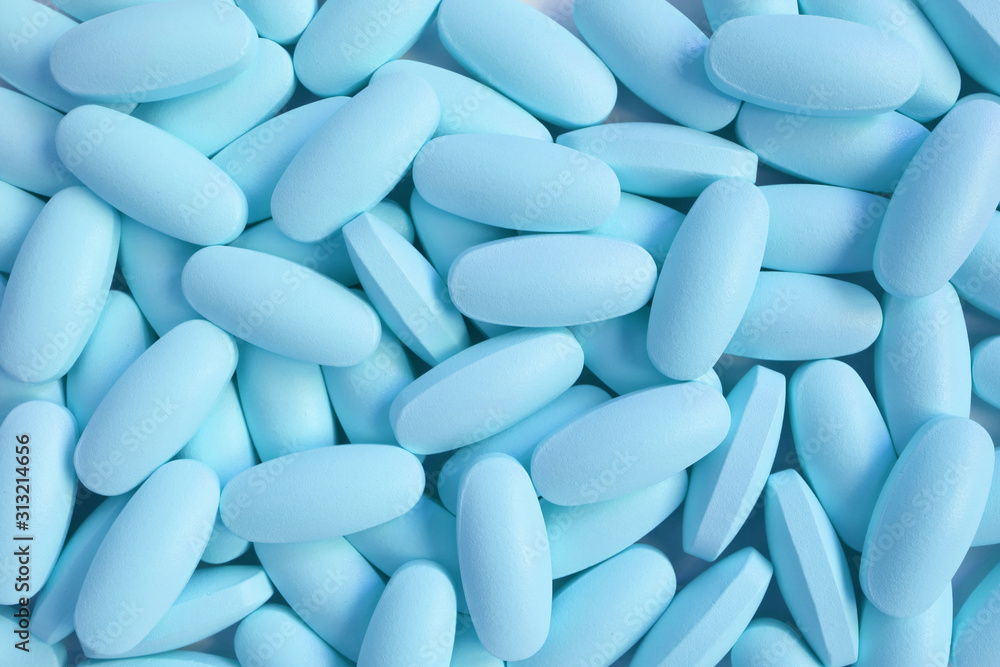 Top view of heap of ice blue oval shaped pills for background or banner Top view of heap of ice blue oval shaped pills for background or banner