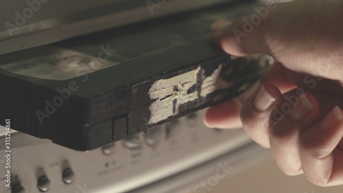 Fotografia hand put Old VHS Video Cassettes iside the Old Video Recorder
