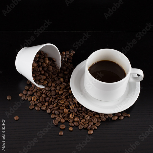 cup of coffee with coffee seeds on a black background